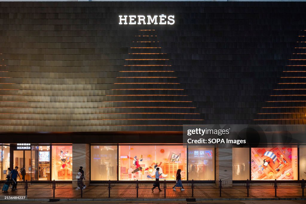 Pedestrians walk past the French high fashion luxury...