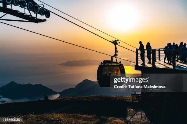 beautiful view of the cable car at sunset, the sea and the mountains in the background of the cabins. - overhead cable car stock pictures, royalty-free photos & images