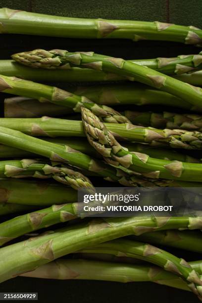 fresh green asparagus on a green background. the concept of healthy eating. - asparagus stock pictures, royalty-free photos & images