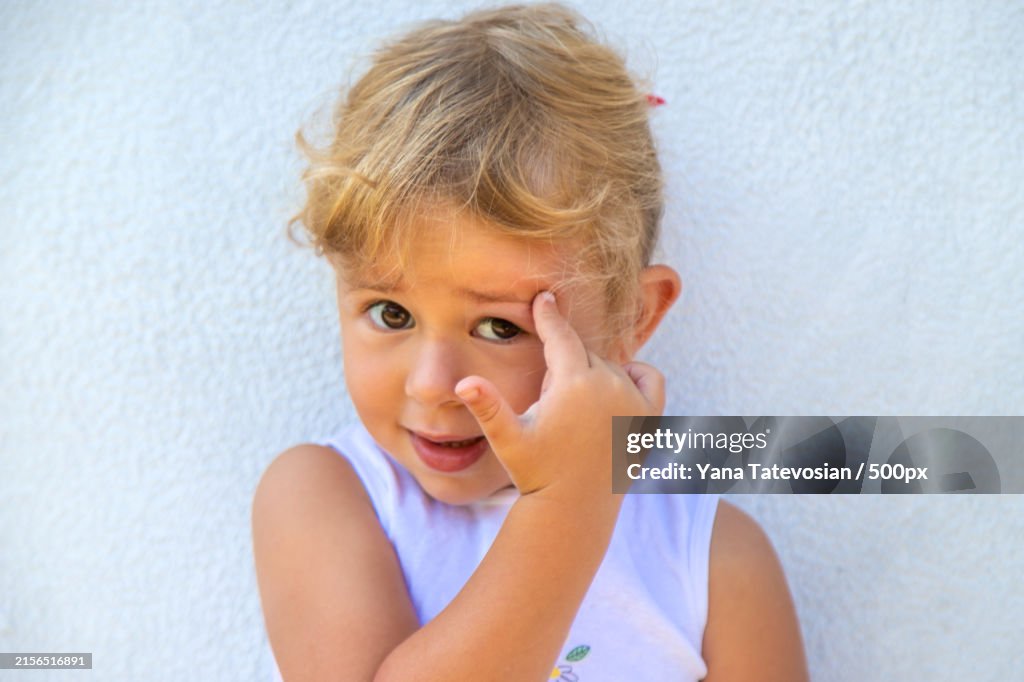 Close-up portrait of cute girl against wall