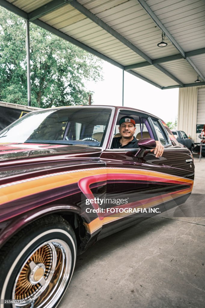 Mid adult Latino male business owner at auto body paint shop