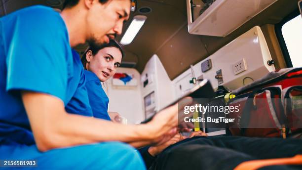 paramedics providing first aid. - paramedic ambulance stock pictures, royalty-free photos & images