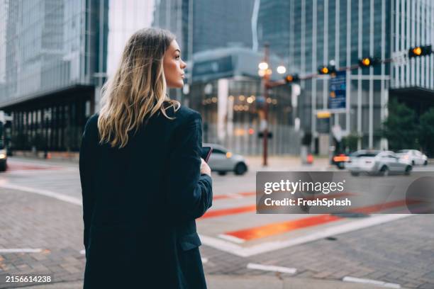 femme attendant de traverser la rue en milieu urbain - traverser photos et images de collection