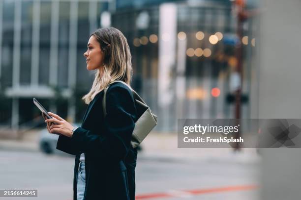 urban woman walking with smartphone in hand downtown - urban exploration stock pictures, royalty-free photos & images