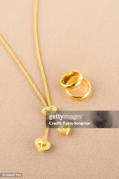 gold necklace and rings on a leather background. - gold chain necklace stock pictures, royalty-free photos & images