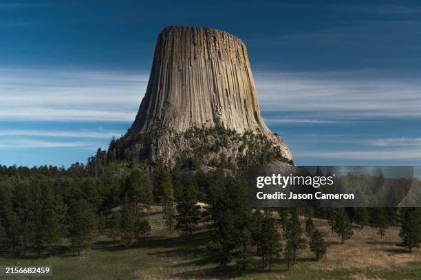 line clouds behind devil's tower - devils tower stock pictures, royalty-free photos & images