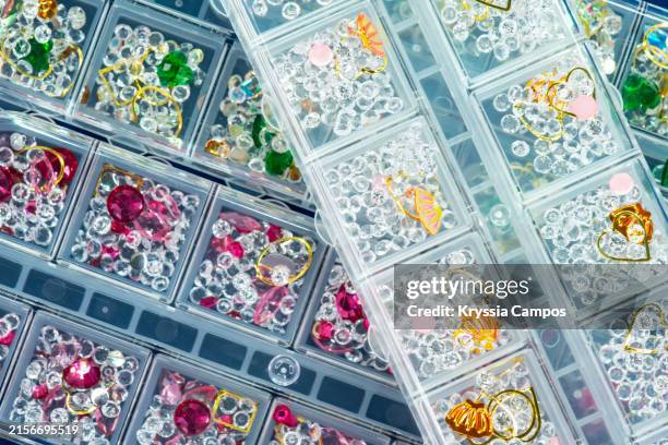 colorful rhinestones for manicure in divided plastic box - rhinestone texture stock pictures, royalty-free photos & images