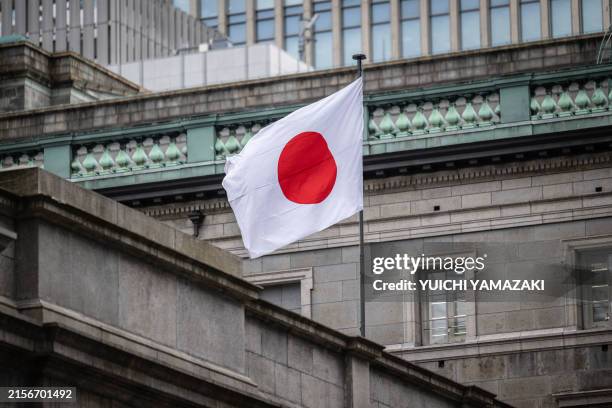 The Japanese national flag is seen at the Bank of Japan headquarters in Tokyo on June 13, 2024.