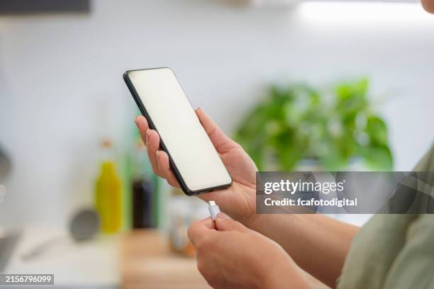 donna che collega il caricabatteria del telefono cellulare cavo usb-c - caricare attività foto e immagini stock