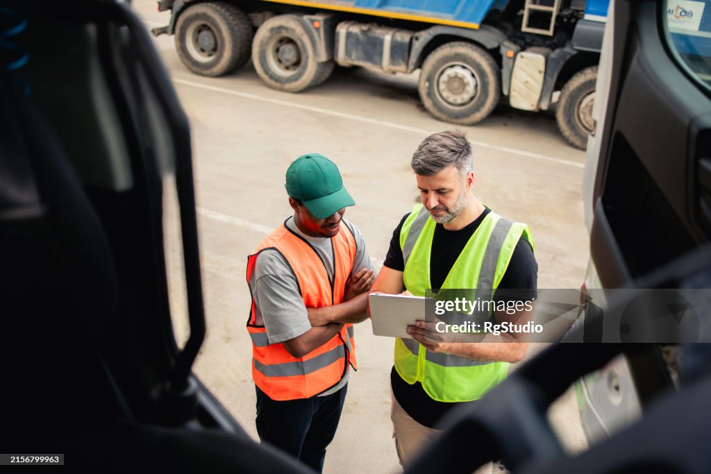Two truck drivers planning the transportation