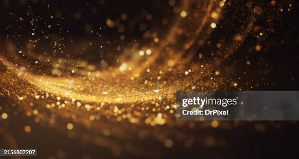 blurry glowing golden particles flow - übersinnliches stock-fotos und bilder