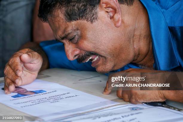 Relative mourns near deceased Cibin Abraham after his coffin arrived on an Indian Air Force plane from Kuwait at the Cochin International Airport in...
