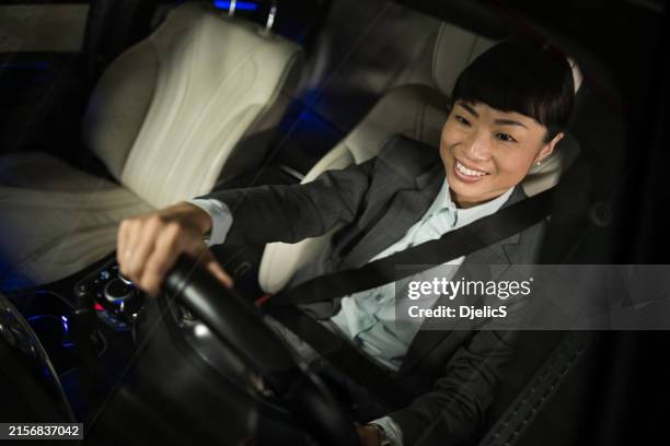 happy asian businesswoman driving a car. - car interior stock pictures, royalty-free photos & images