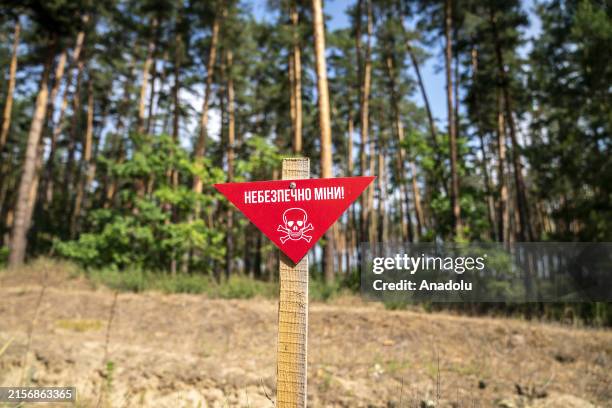 Warning sign is seen as an emergency demining team carries out demining and explosive destruction work in Kharkiv region, Ukraine on June 06, 2024. A...