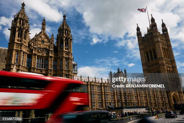 London double decker bus goes past the Palace of Westminster, home to the Houses of Parliament, in central London, on June 14, 2024. Fourteen years...