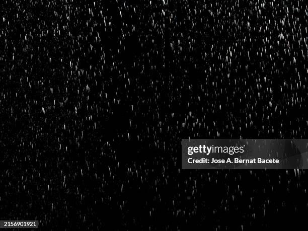 small drops of water in downward motion on a black background. - shower stock pictures, royalty-free photos & images