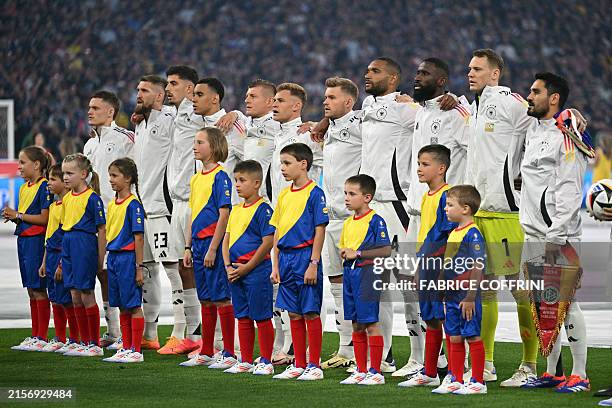 The German team listen to the national anthems prior to the UEFA Euro 2024 Group A football match between Germany and Scotland at the Munich Football...