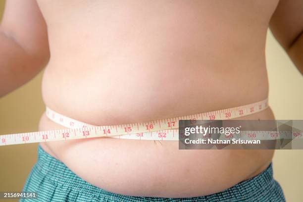 obese fat boy measuring tape - preocupación por el cuerpo fotografías e imágenes de stock