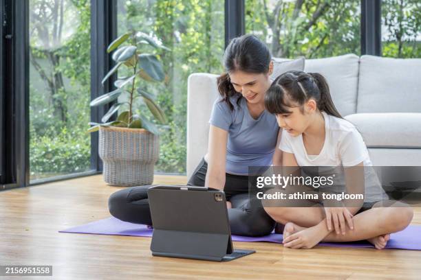 mother and daughter watching laptop together. - sitting on ground stock pictures, royalty-free photos & images