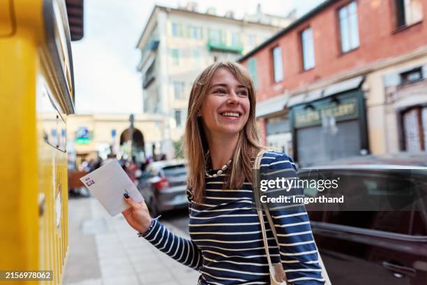 young woman sending a postcard from nice, alpes-maritimes, france - brevlåda bildbanksfoton och bilder