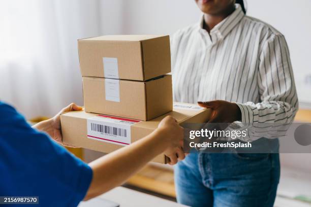 courier delivering packages to customer at home - post office stock pictures, royalty-free photos & images