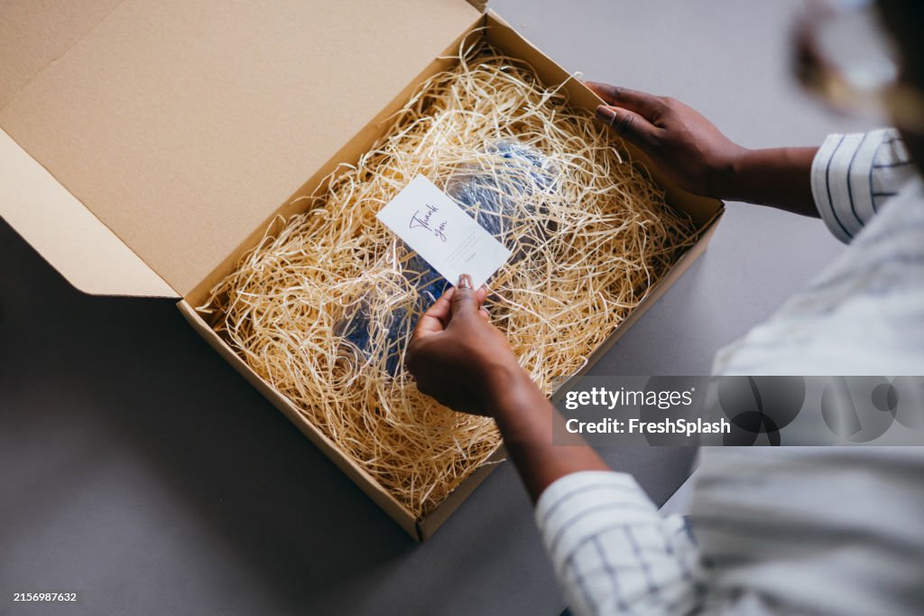 Woman Opening Package with Thank You Card in Box