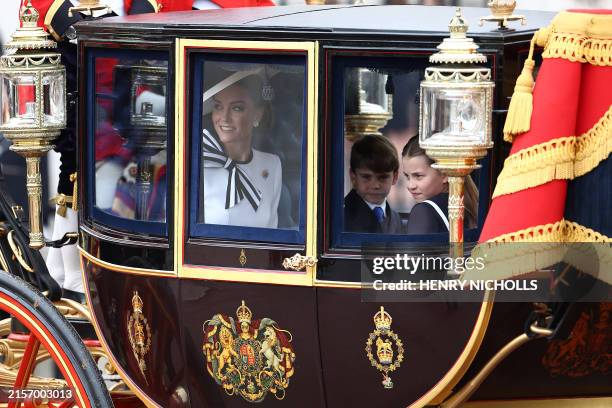 Britain's Catherine, Princess of Wales, smiles next to Britain's Princess Charlotte of Wales and Britain's Prince Louis of Wales inside the Glass...