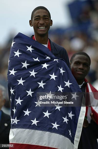 Jason Richardson of the USA watches his national flag being raised up the flag pole after he wins gold medal for the 400m Hurdles with his team mate...