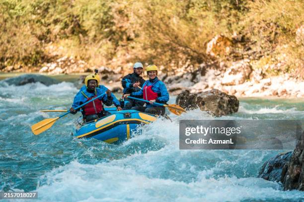 mature rafting enthusiasts conquer rapids with guide - white water rafting stock pictures, royalty-free photos & images