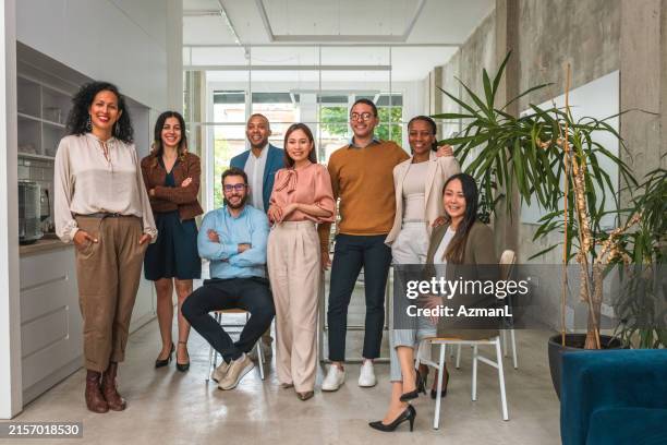 a group photo of multicultural professionals in business attire - groepsfoto stockfoto's en -beelden