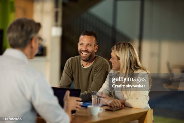 happy couple talking to their insurance agent on a meeting in the office. - gerente de banco imagens e fotografias de stock