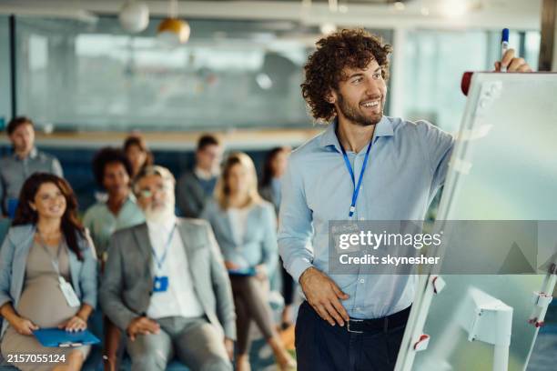 heureux pdg masculin dessinant des plans lors de la présentation dans la salle du conseil. - niveau de scolarisation photos et images de collection