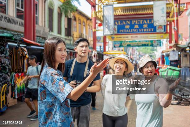 tour guide friends walking through street market - indian tour guide stock pictures, royalty-free photos & images