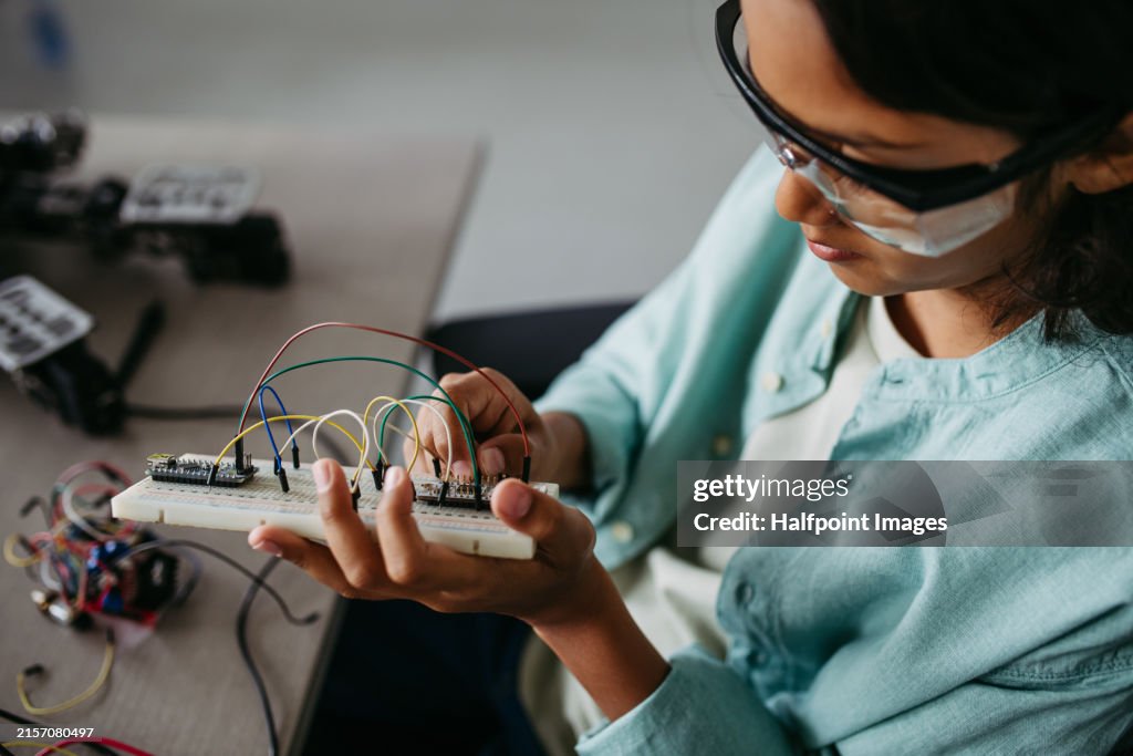 Young curious boy interested in robotics, assembling circuit board. Basic of science, technology, engineering in elementary schools. Future scientists.