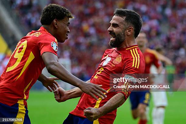 Spain's defender Dani Carvajal celebrates with Spain's forward Lamine Yamal after scoring his team's third goal during the UEFA Euro 2024 Group B...