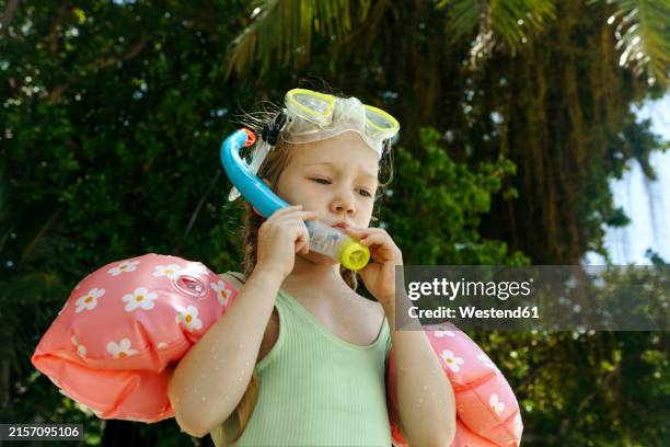 girl wearing water wings and swimming goggles with snorkel at beach - arm band stock pictures, royalty-free photos & images