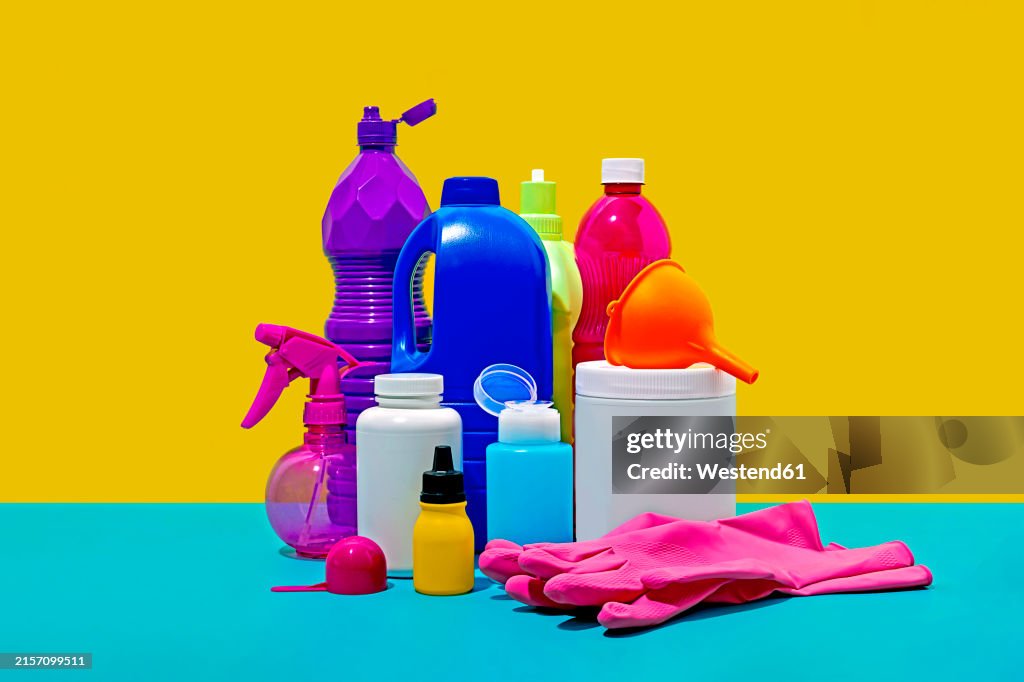 Still life of household cleaning products against yellow background