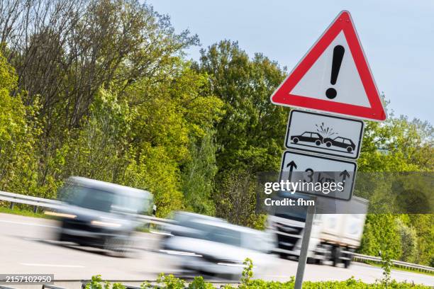 trucks and cars on german autobahn with accident warning sign - kilometer stock-fotos und bilder