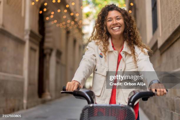 woman riding bike while visiting city - campaign-button stock pictures, royalty-free photos & images