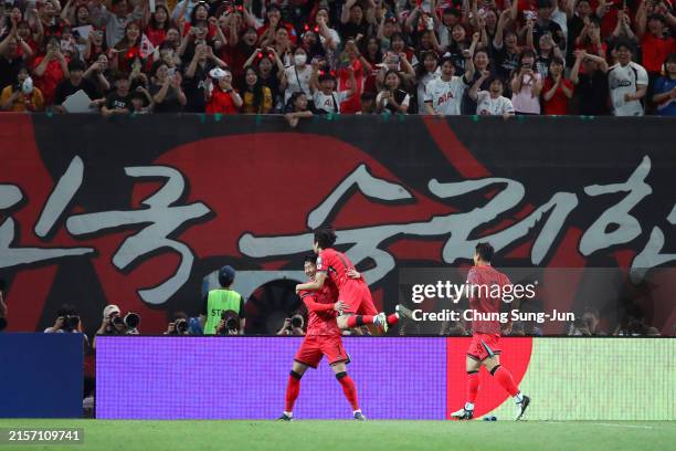 Lee Kang-in of South Korea celebrates with teammates Joo Min-kyu and Son Heung-min after scoring the team's first goal during the FIFA World Cup...