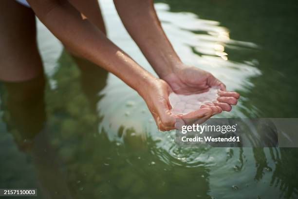 woman holding water with hands in lake - hands cupped stock pictures, royalty-free photos & images