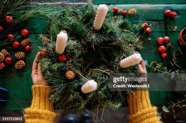 florist making wreath on table in store - advent wreath stock pictures, royalty-free photos & images