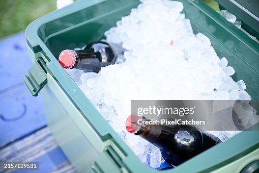 Cooler box with ice and glass bottles of beer or cold drinks Cooler box with ice and glass bottles of beer or cold drinks