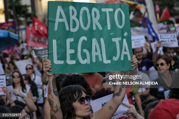Woman holds a placard that reads "Legal abortion now" during a protest against an anti-abortion bill under evaluation at the Brazilian National...