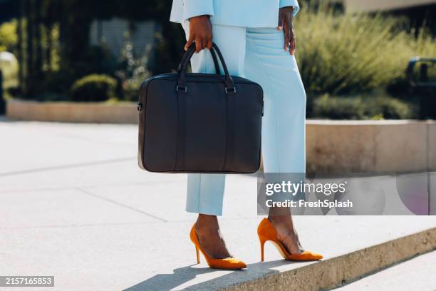 professional woman with briefcase and bright orange heels outdoors - blue purse stock pictures, royalty-free photos & images