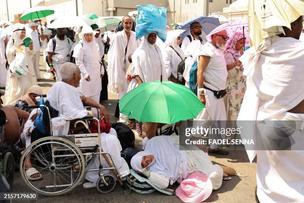 Woman effected by the scorching heat rests as Muslim pilgrims arrive to perform the symbolic 'stoning of the devil' ritual as part of the hajj...
