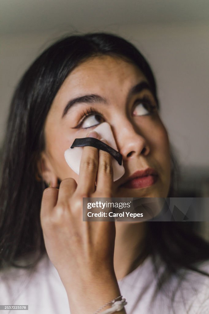 Closeup young latina woman applying some powder on cheeks