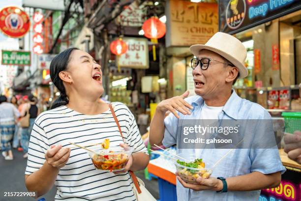 tourist eating spicy street food at roadside - pungency stock pictures, royalty-free photos & images