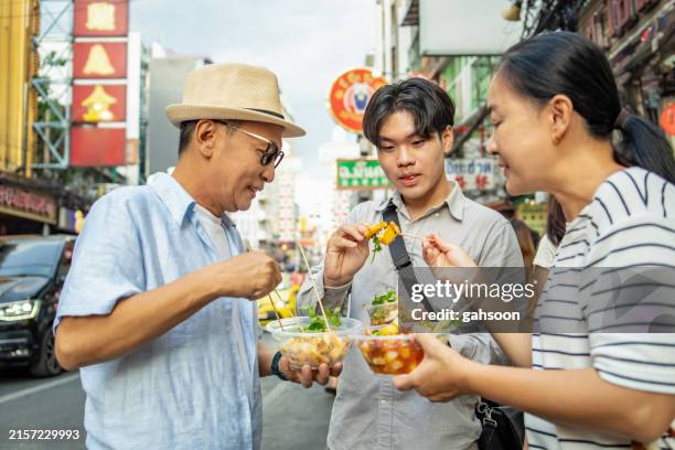 family enjoying street food in roadside - taste test stock pictures, royalty-free photos & images