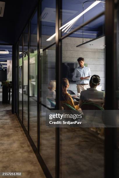 young caucasian businessman presenting new business strategy to a multiracial team during business meeting - kommunikationssätt bildbanksfoton och bilder